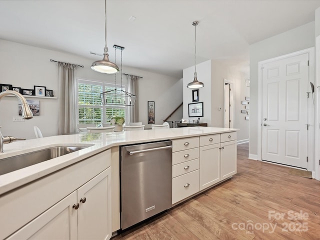 9405 Gladden Hill Ln, Pineville, NC 28134 - kitchen with dishwasher, a sink, light countertops, light wood-style flooring, and decorative light fixtures
