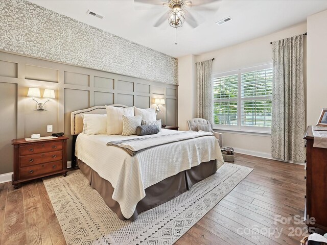 9405 Gladden Hill Ln, Pineville, NC 28134 - bedroom with hardwood / wood-style floors, baseboards, a decorative wall, and a ceiling fan