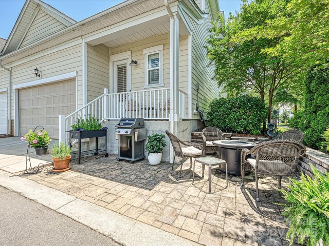 9405 Gladden Hill Ln, Pineville, NC 28134 - view of patio / terrace featuring area for grilling, driveway, an attached garage, and an outdoor fire pit