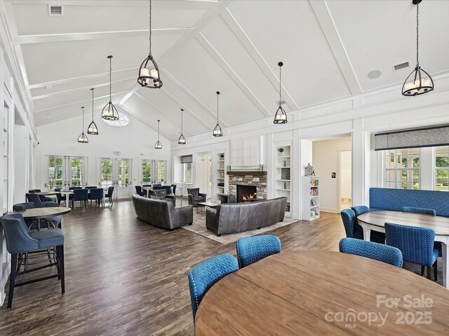 9405 Gladden Hill Ln, Pineville, NC 28134 - dining room with wood finished floors, built in features, a stone fireplace, high vaulted ceiling, and beamed ceiling