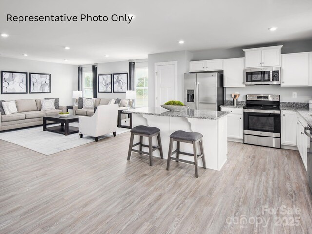 581 Nesbe St Unit 2223, Lancaster, SC 29720 - kitchen featuring appliances with stainless steel finishes, recessed lighting, a center island, light stone counters, and light wood-style flooring