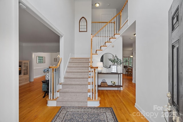 11917 Ulsten Ln, Huntersville, NC 28078 - foyer featuring a fireplace, wood finished floors, stairs, a high ceiling, and crown molding