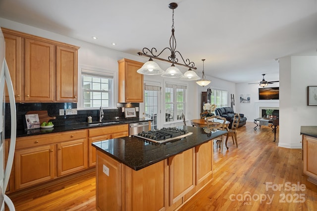11917 Ulsten Ln, Huntersville, NC 28078 - kitchen with appliances with stainless steel finishes, open floor plan, a center island, decorative backsplash, and light wood-style flooring