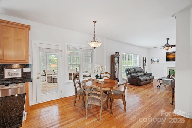 11917 Ulsten Ln, Huntersville, NC 28078 - dining space with light wood-type flooring, a warm lit fireplace, and ceiling fan