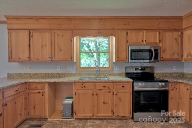 7869 Cherry Point Dr, Denver, NC 28037 - kitchen with stainless steel appliances, light stone countertops, light brown cabinets, and a textured ceiling