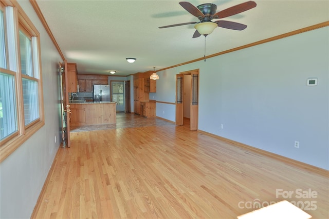 7869 Cherry Point Dr, Denver, NC 28037 - unfurnished living room featuring crown molding, light wood-style floors, and a ceiling fan