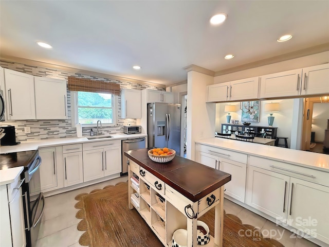5033 Baylor Dr, Charlotte, NC 28210 - kitchen with stainless steel appliances, a sink, decorative backsplash, light countertops, and recessed lighting