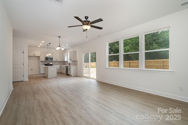 718 Lithia Inn Rd, Lincolnton, NC 28092 - unfurnished living room featuring ceiling fan, recessed lighting, baseboards, light wood finished floors, and a sink
