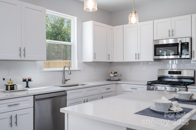 718 Lithia Inn Rd, Lincolnton, NC 28092 - kitchen featuring stainless steel appliances, a sink, light countertops, white cabinets, and hanging light fixtures