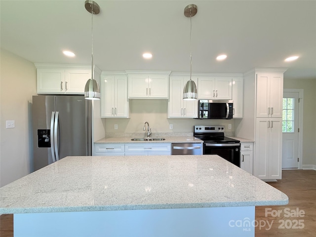 111 W Perry St, Heath Springs, SC 29058 - kitchen featuring stainless steel appliances, a sink, dark wood-style flooring, a center island, and white cabinets