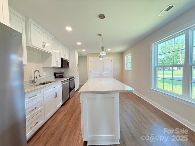 111 W Perry St, Heath Springs, SC 29058 - kitchen featuring stainless steel appliances, a sink, a kitchen island, recessed lighting, and white cabinets