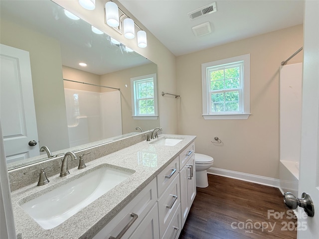 111 W Perry St, Heath Springs, SC 29058 - bathroom with baseboards, double vanity, toilet, wood finished floors, and washtub / shower combination