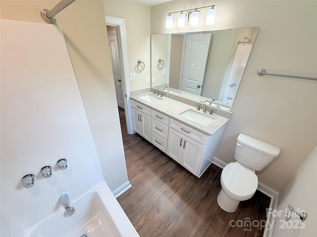 111 W Perry St, Heath Springs, SC 29058 - bathroom featuring toilet, wood finished floors, double vanity, a tub, and baseboards