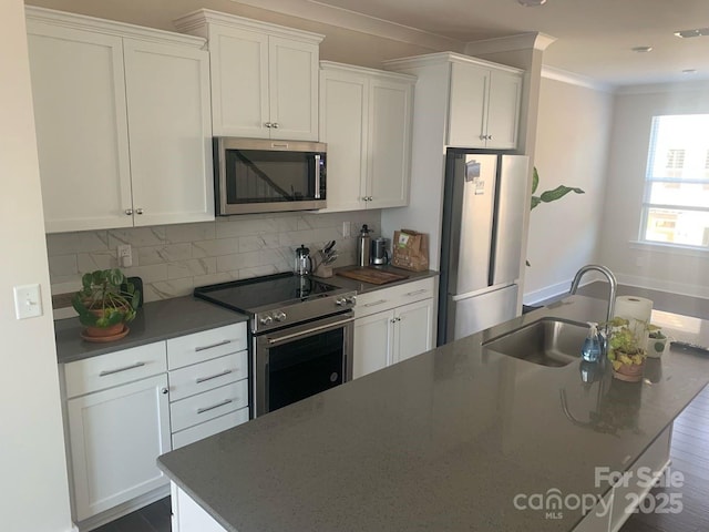 3007 Citizens Ln, Charlotte, NC 28205 - kitchen featuring appliances with stainless steel finishes, a sink, white cabinets, tasteful backsplash, and crown molding