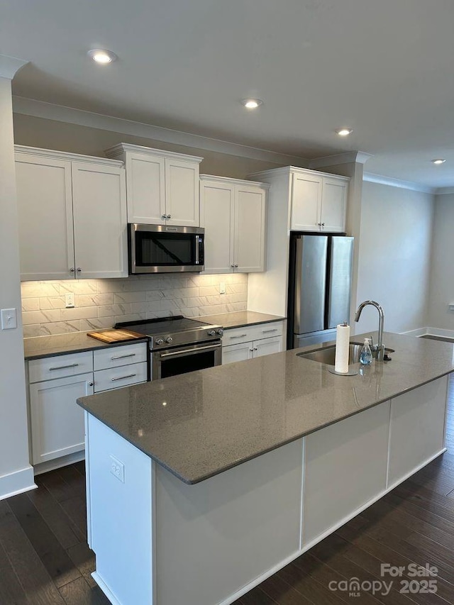 3007 Citizens Ln, Charlotte, NC 28205 - kitchen featuring appliances with stainless steel finishes, a sink, ornamental molding, an island with sink, and white cabinetry