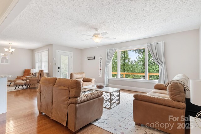 6294 Southlake Dr, Hickory, NC 28601 - living room featuring light wood-style floors, a ceiling fan, a chandelier, and a textured ceiling