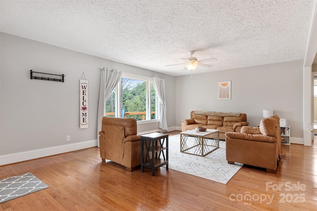 6294 Southlake Dr, Hickory, NC 28601 - living room with light wood finished floors, a ceiling fan, a textured ceiling, and baseboards