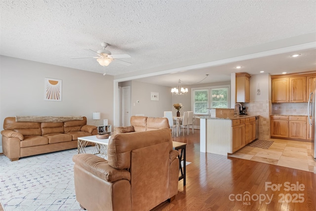 6294 Southlake Dr, Hickory, NC 28601 - living room with a chandelier, ceiling fan, light wood-style flooring, a textured ceiling, and recessed lighting