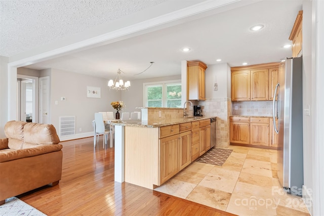6294 Southlake Dr, Hickory, NC 28601 - kitchen with stainless steel appliances, a sink, a peninsula, tasteful backsplash, and light stone countertops