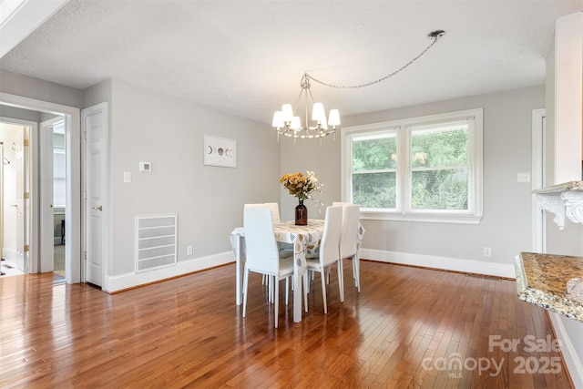 6294 Southlake Dr, Hickory, NC 28601 - dining room featuring hardwood / wood-style flooring, a chandelier, baseboards, and a textured ceiling