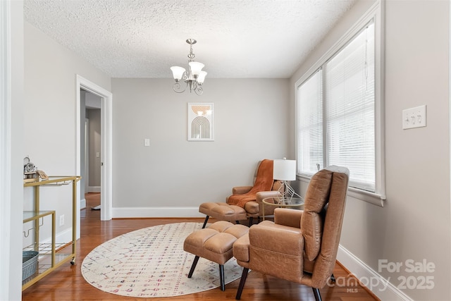 6294 Southlake Dr, Hickory, NC 28601 - living area featuring a chandelier, wood finished floors, a textured ceiling, and baseboards