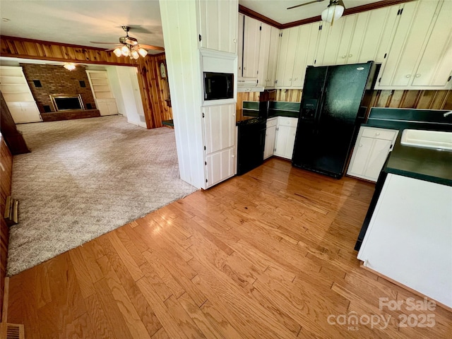 1585 Salem Church Rd, Lincolnton, NC 28092 - kitchen featuring a ceiling fan, a sink, black refrigerator with ice dispenser, dark countertops, and wood walls