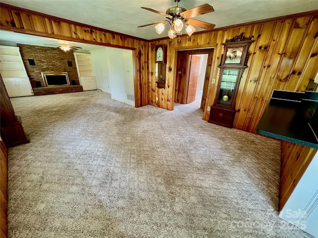 1585 Salem Church Rd, Lincolnton, NC 28092 - unfurnished living room with ceiling fan, wood walls, carpet floors, crown molding, and a fireplace