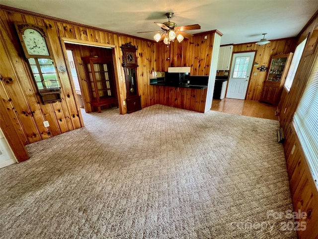 1585 Salem Church Rd, Lincolnton, NC 28092 - kitchen featuring wooden walls, crown molding, open floor plan, a ceiling fan, and carpet floors