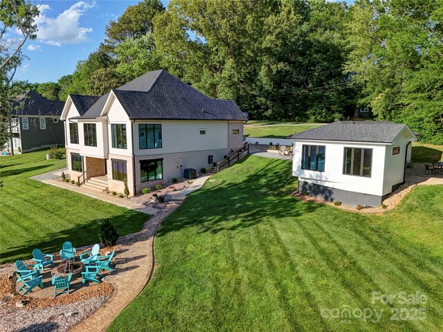 445 Sundown Rd, Mooresville, NC 28117 - back of property featuring an outdoor fire pit, a yard, cooling unit, and an outbuilding