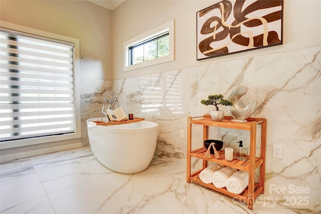 445 Sundown Rd, Mooresville, NC 28117 - bathroom featuring tile walls, marble tiled flooring, a wainscoted wall, and a freestanding tub
