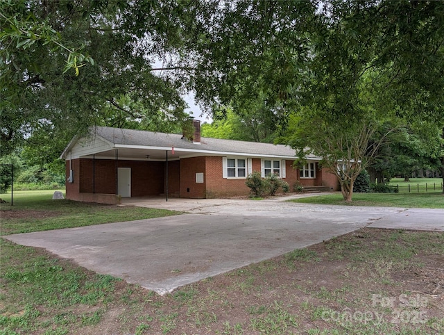 5628 White Store Rd, Wingate, NC 28174 - ranch-style home with a front yard, a chimney, concrete driveway, brick siding, and a carport