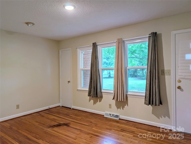 5628 White Store Rd, Wingate, NC 28174 - spare room with wood finished floors, baseboards, healthy amount of natural light, and a textured ceiling