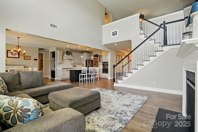 1478 Imperial Ct, York, SC 29745 - living room featuring a chandelier, stairway, a high ceiling, wood finished floors, and baseboards