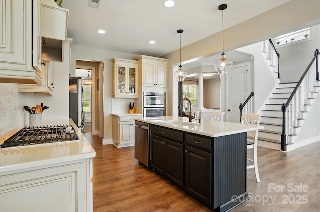 1478 Imperial Ct, York, SC 29745 - kitchen featuring stainless steel appliances, ornate columns, a sink, a breakfast bar area, and decorative backsplash