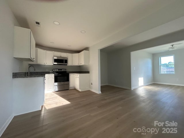 360 Ledbetter Rd, Spindale, NC 28160 - kitchen with stainless steel appliances, dark wood-type flooring, baseboards, open floor plan, and white cabinetry