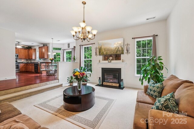 5021 Meadow Woods Dr, Lowell, NC 28098 - living room featuring a chandelier, dark colored carpet, a fireplace with flush hearth, and baseboards