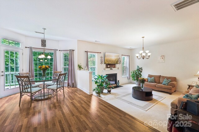 5021 Meadow Woods Dr, Lowell, NC 28098 - living room featuring a chandelier, wood finished floors, baseboards, and a fireplace with flush hearth
