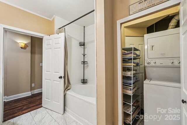 5021 Meadow Woods Dr, Lowell, NC 28098 - full bath with estacked washer and dryer, marble look tiles, shower / bath combo, crown molding, and baseboards