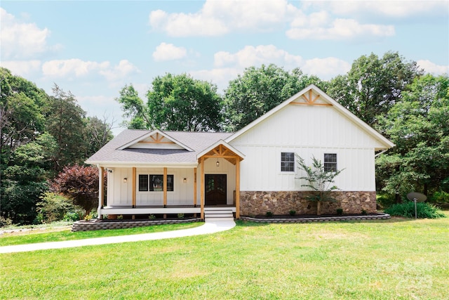 8340 Brief Rd, Mint Hill, NC 28227 - modern farmhouse with board and batten siding, a front yard, covered porch, a shingled roof, and stone siding