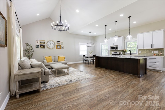 8340 Brief Rd, Mint Hill, NC 28227 - kitchen with stainless steel appliances, light countertops, white cabinets, open floor plan, and a chandelier