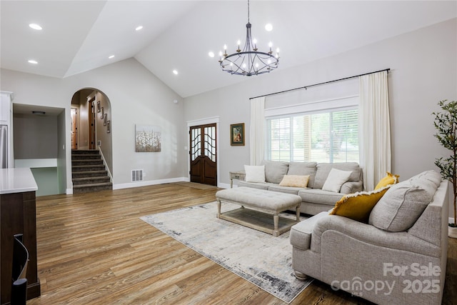 8340 Brief Rd, Mint Hill, NC 28227 - living room with arched walkways, light wood finished floors, a chandelier, plenty of natural light, and high vaulted ceiling
