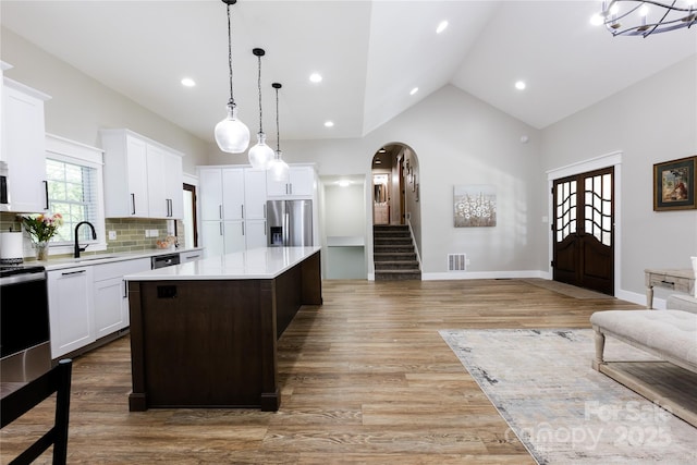 8340 Brief Rd, Mint Hill, NC 28227 - kitchen with appliances with stainless steel finishes, light countertops, open floor plan, arched walkways, and light wood finished floors