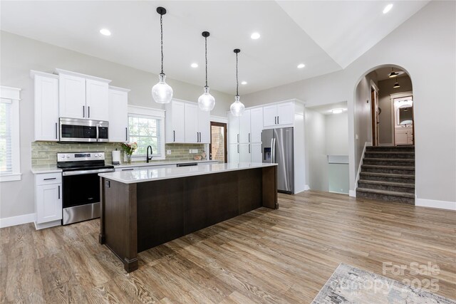 8340 Brief Rd, Mint Hill, NC 28227 - kitchen with appliances with stainless steel finishes, light countertops, a kitchen island, a sink, and tasteful backsplash