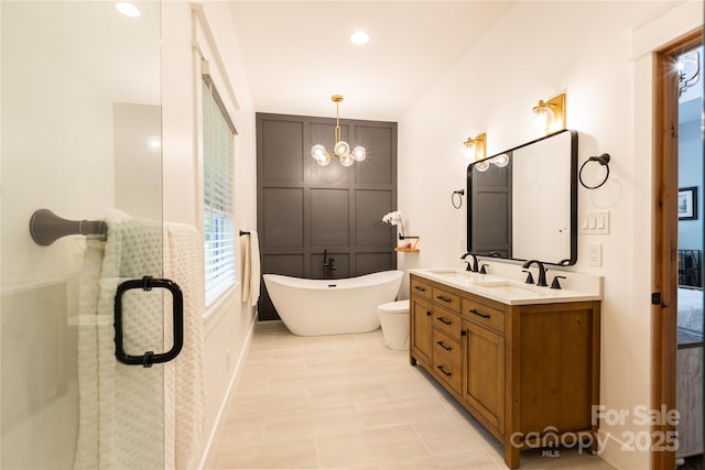 8340 Brief Rd, Mint Hill, NC 28227 - bathroom with double vanity, a chandelier, a stall shower, a freestanding bath, and toilet