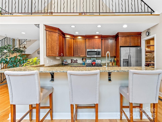 350 Mckissick Rd, Flat Rock, NC 28731 - kitchen featuring stainless steel appliances, a peninsula, light wood finished floors, a breakfast bar area, and a sink