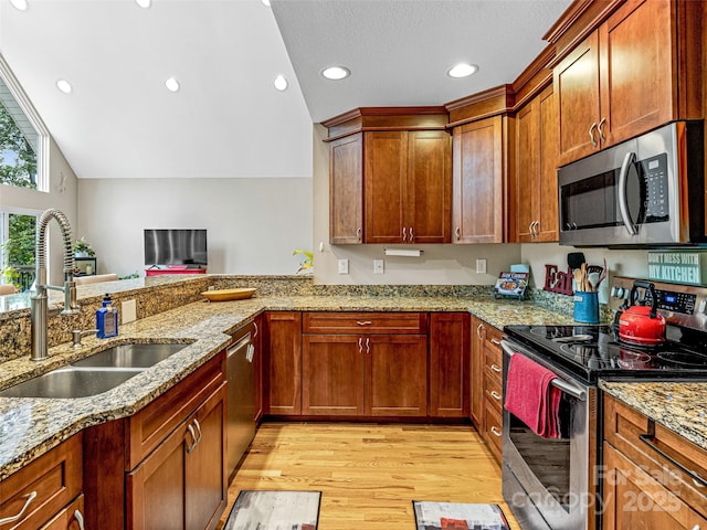 350 Mckissick Rd, Flat Rock, NC 28731 - kitchen featuring appliances with stainless steel finishes, a sink, light wood-style floors, vaulted ceiling, and light stone countertops