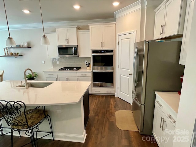 5005 Blue Serenity Ct, Denver, NC 28037 - kitchen featuring appliances with stainless steel finishes, a sink, ornamental molding, dark wood-type flooring, and white cabinets