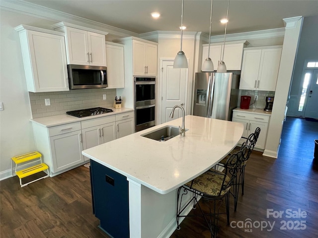 5005 Blue Serenity Ct, Denver, NC 28037 - kitchen featuring stainless steel appliances, a sink, dark wood-style flooring, ornamental molding, and white cabinets