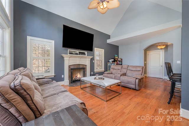 6057 Erie View Ct, Denver, NC 28037 - living area featuring high vaulted ceiling, ceiling fan, arched walkways, a fireplace, and wood finished floors