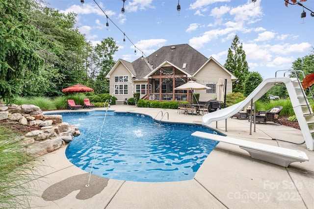 6057 Erie View Ct, Denver, NC 28037 - outdoor pool featuring a water slide, a patio, a diving board, a sunroom, and outdoor dining space